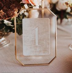 a close up of a table with flowers in vases and a number one sign