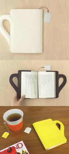 there is a coffee cup and an open book on the table next to each other