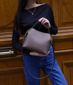 The Medium Swan bag in Dark Taupe, crafted from smooth calf leather, embodies a subtle and versatile elegance, perfectly adapting to a wide range of outfits, from the understated to the boldly colored. Its ideal size provides generous space for your daily essentials while maintaining a chic and streamlined appearance.
The Dark Taupe color, subtle and rich, elegantly harmonizes with a broad spectrum of colors. It naturally pairs with neutral tones such as cream, ivory, or light grey, creating a sophisticated and timeless look. For a striking contrast, combine it with more vivid and bright colors like turquoise, coral, or emerald green.
Precisely crafted in Italy, the Medium Swan bag in Dark Taupe stands out with its refined metallic finishes and elegant design. Its versatility allows it to Chic Bags With Smooth Grain Finish, Chic Smooth Grain Shoulder Bag For Office, Smooth Grain Top Handle Bucket Bag For Work, Elegant Bags With Smooth Grain Finish, Elegant Bags With Smooth Grain, Luxury Smooth Grain Bucket Bag For Work, Chic Top Handle Bucket Bag, Solid Color Office Bag With Smooth Grain, Office Bag With Smooth Grain