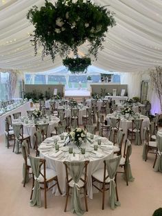 tables and chairs are set up in a tented area for a formal function or wedding reception