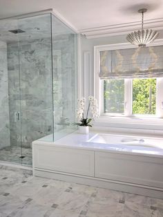 a bathroom with a tub, shower and window