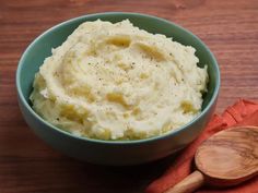 a bowl filled with mashed potatoes on top of a wooden table