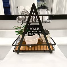 a bathroom sink with a black and white sign that says wash your hands on it