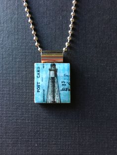 a necklace with an image of a lighthouse on it and a chain attached to it