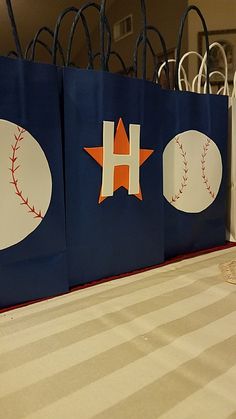 three bags with baseballs and stars on them are sitting on a table in front of some chairs