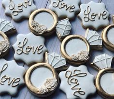 decorated cookies are arranged on a table with gold trimmings and white frosting