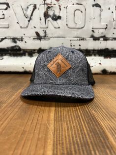 Introducing the Southern Casanova Black Topo Leather Patch Trucker Mesh Back Cap, a blend of rugged charm and Southern sophistication. Crafted with precision and style in mind, this cap is the epitome of outdoor elegance. The sleek black design serves as the canvas for a stunning leather patch featuring a topographical map design, adding an adventurous touch to your ensemble. Whether you're hitting the trails or enjoying a day in the city, this cap effortlessly combines functionality with fashio Black Leather Travel Hat, Black Adjustable Hat For Everyday Use, Adjustable Black Hat For Everyday, Adjustable Black Hat, Black Leather Hats For Outdoor Activities, Black Leather Hat For Outdoor, Urban Fitted Hat With Curved Bill For Outdoor, Urban Curved Bill Fitted Hat For Outdoor, Adjustable Charcoal Hat For Outdoor