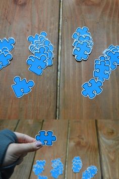 someone is holding a piece of blue puzzle on a wooden table with the pieces missing