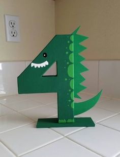 the number four is made to look like a green dinosaur's head with teeth