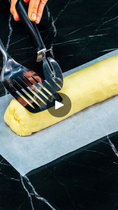 a person using a fork and knife to cut dough