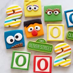 decorated cookies are arranged in the shape of sesame street characters, with words on them