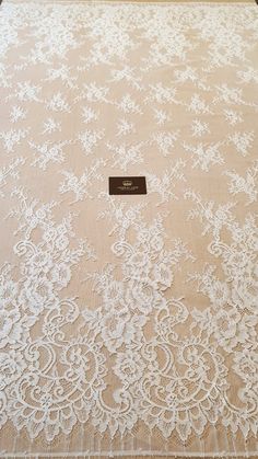 a table cloth with white lace on it and a name tag in the middle,