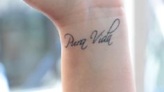 a woman's wrist tattoo with the word dog mom written on her left arm