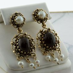 14K Yellow Gold Black Onyx and Pearl Drop Ear Pendants, 8x10mm high dome oval cabochons, 3 pearl drops with larger pearl on stud, 1 1/2 inch x 1/2 inch, baroque style, Circa 1960, 7.3 grams SKU # BB275E26 This listing contains photographs of the actual item you will receive. Our items are in excellent condition with little or no signs of wear and many are one of a kind pre-owned estate finds. Please look closely at the pictures in this listing as they are part of the product description. Please Victorian Oval Jewelry For Opera, Vintage Oval Cabochons For Formal Occasions, Luxury Oval Jewelry For Opera, Black Cabochon Jewelry For Wedding, Black Cabochon Wedding Jewelry, Black Cabochon Victorian Jewelry, Antique Black Oval Cabochon Jewelry, Victorian Pearl Drop Jewelry For Formal Occasions, Vintage Pearl Drop Jewelry For Formal Occasions