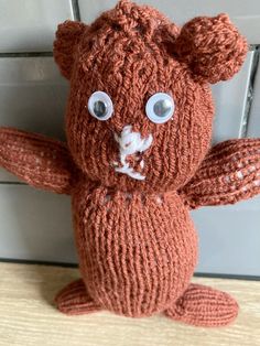 an orange knitted teddy bear with big eyes