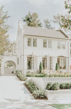 a large white house sitting on top of a lush green field