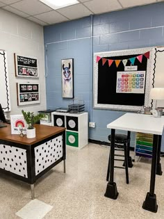 a classroom with desks, chairs and pictures on the wall