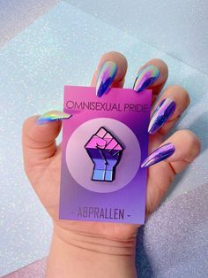 a person holding up a card with purple and blue nail polish on it