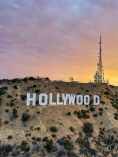 the hollywood sign on top of a hill with a cell phone tower in the background