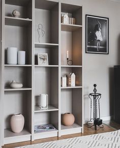 a living room filled with lots of white bookshelves