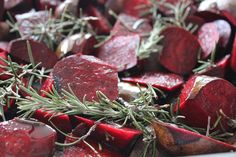 beets with rosemary sprigs on top of them are ready to be cooked