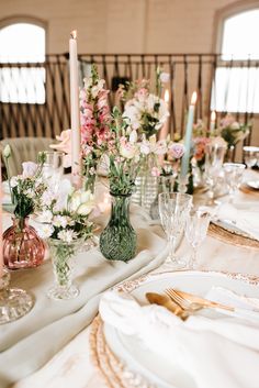 the table is set with flowers, candles and plates for dinner or bridal party guests to enjoy