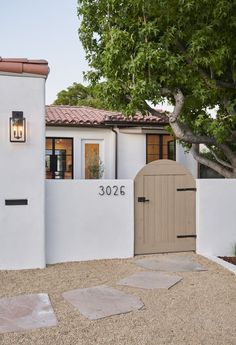 a white stucco house with a brown door