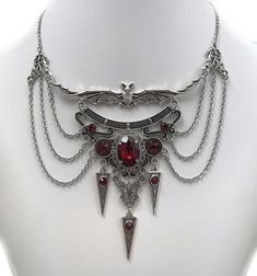 This dramatic Gothic Vampire Bat necklace features an antique silver open winged bat, filigrees and pendants, adorned with dazzling DARK RUBY RED/GARNET glass jewels. This piece is then finished off with perfectly draped stainless steel cable chain. Decorated length portion is  5 3/4" wide and 4" tall in the very center (bat ears to bottom point). Necklace is adjustable 15"-18" in length.  It is worn with soldered stainless steel cable chain and closes with a lobster clasp.If you would like a di Manga Jewelry, Vampire Girlfriend, Gothic Jewelry Diy, Bat Ears, Vampire Necklace, Vampire Jewelry, Bat Necklace, Victorian Necklace, Jewelry Gothic