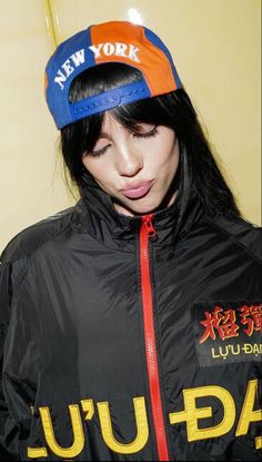 a woman wearing a new york jacket and hat