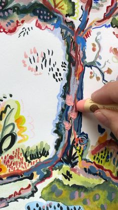 a person is drawing on a piece of paper with colored pencils and watercolor