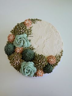 a cake decorated with flowers and succulents