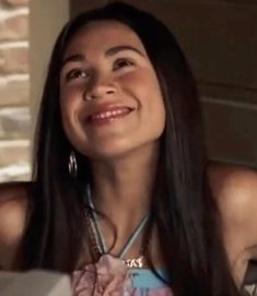 a woman smiling while sitting at a table