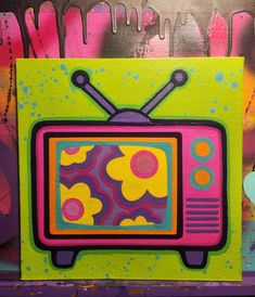 a painting of a tv with flowers painted on the front and sides, in bright colors