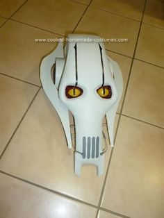 a white mask with yellow eyes on the floor