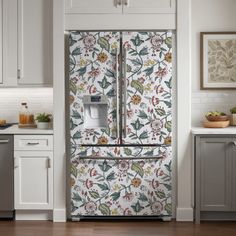 a kitchen with white cabinets and floral wallpaper on the door, along with a stainless steel refrigerator