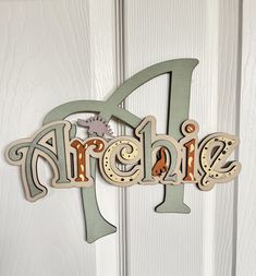 a wooden sign with the word arche on it's side hanging from a white door