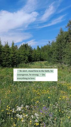 a sign in the middle of a field with wildflowers and trees behind it