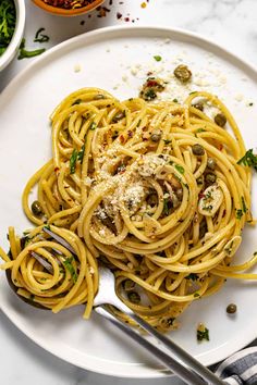 a white plate topped with pasta covered in sauce and parmesan sprinkles