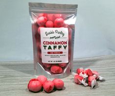 a bag of cinnamon taffys next to some candy candies on a table