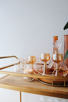 a tray with wine glasses and candles on it