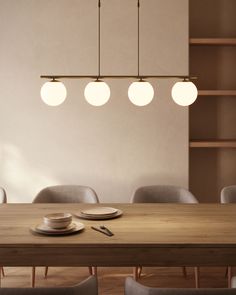 a wooden table with plates and cups on it in front of a bookshelf