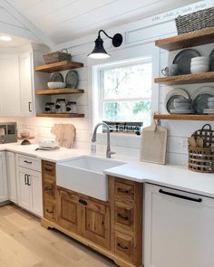 a kitchen with white cabinets and open shelves on the wall above the sink is instagram