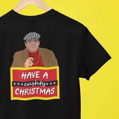 a t - shirt with an image of a man holding a sign that says have a cushy christmas