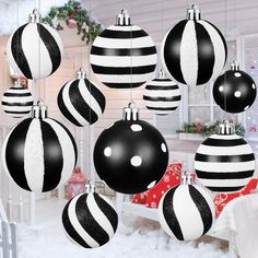 black and white ornaments hanging from the ceiling in front of a christmas tree with snow