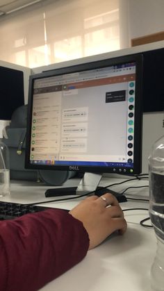 a person sitting at a desk with a computer monitor and keyboard in front of them