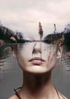 a woman's face is reflected in the water with plants growing out of her head