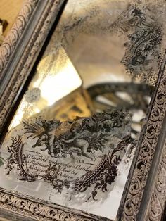 an ornate silver framed mirror sitting on top of a table