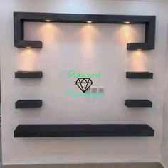 a white wall with some black shelves and lights on the top, and a diamond in the middle