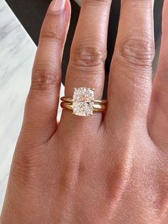 a woman's hand with a ring on it and a diamond in the middle