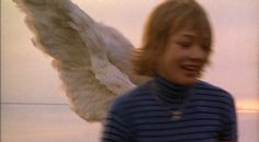 a woman with an angel wings on her head and blue shirt in the foreground